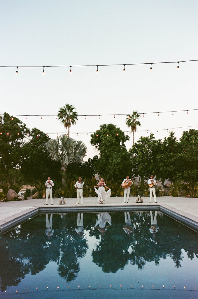 mariachi band playing next to a pool during a cabo wedding