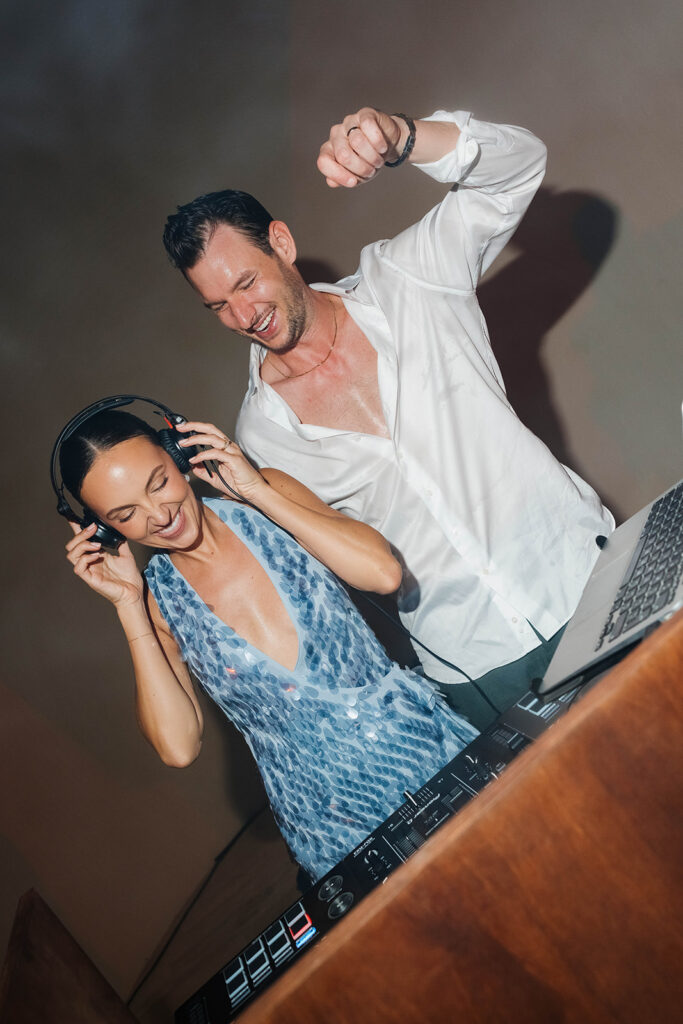 bride and groom at the dj booth during their wedding reception