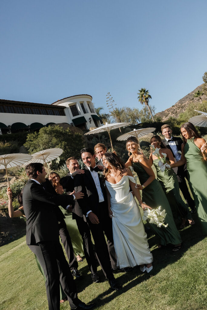 joyful wedding couple with their wedding party