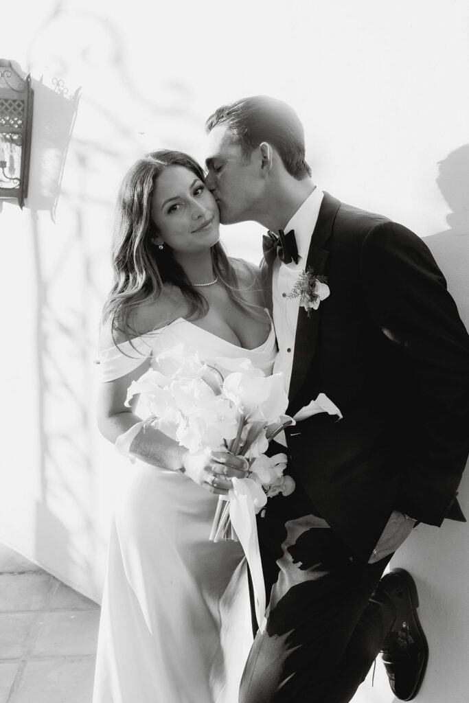groom kissing bride on the cheek