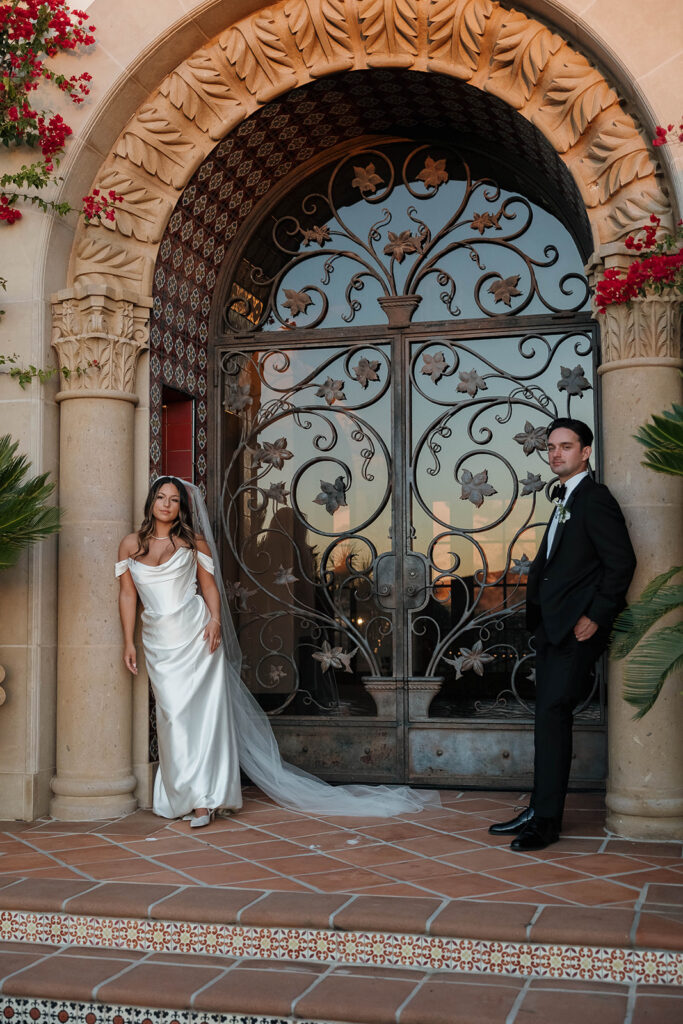 bride and groom posing in front of their spanish villa inspired wedding venue - hummingbird nest ranch in California