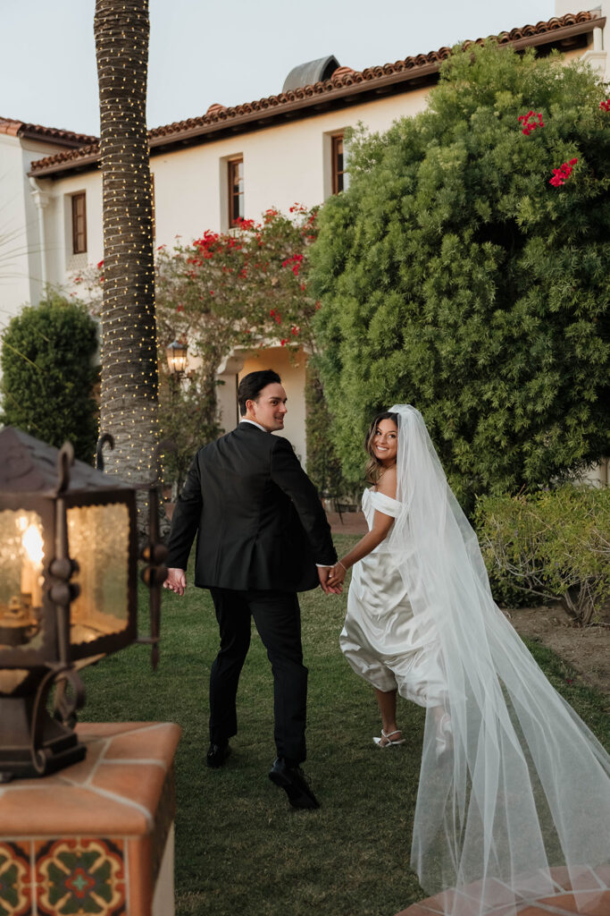 bride and groom posing in front of their spanish villa inspired wedding venue - hummingbird nest ranch in California