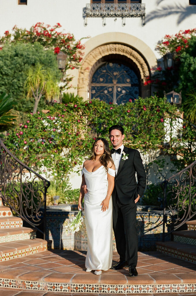 bride and groom posing in front of their spanish villa inspired wedding venue - hummingbird nest ranch in California