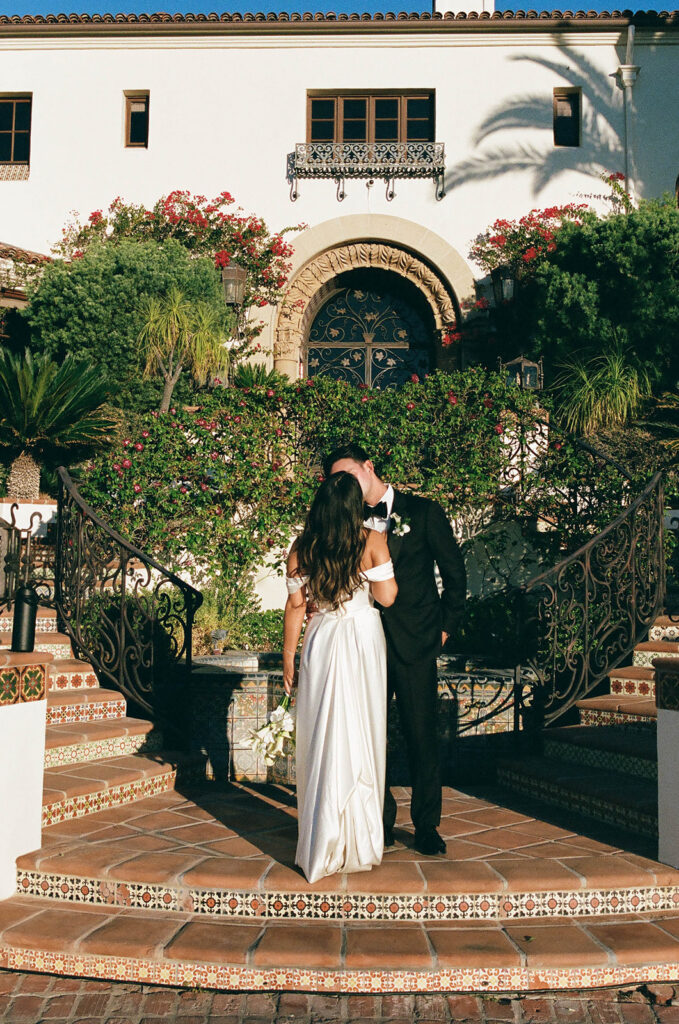 bride and groom posing in front of their spanish villa inspired wedding venue - hummingbird nest ranch in California