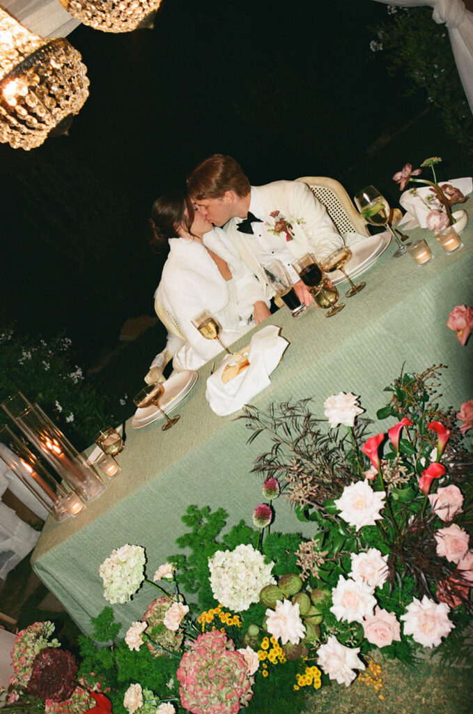 bride and groom kissing at the sweetheart table