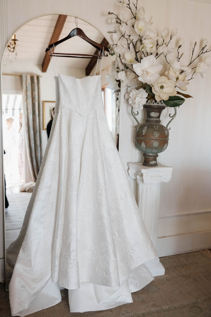 wedding dress hanging in front of the mirror