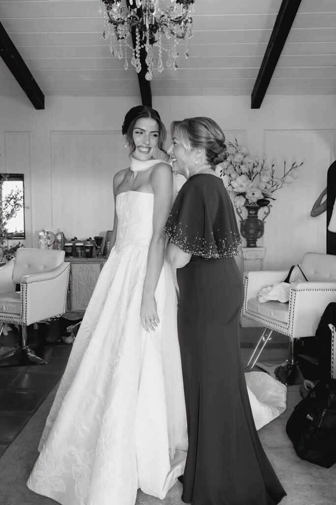 mom helping bride into her dress