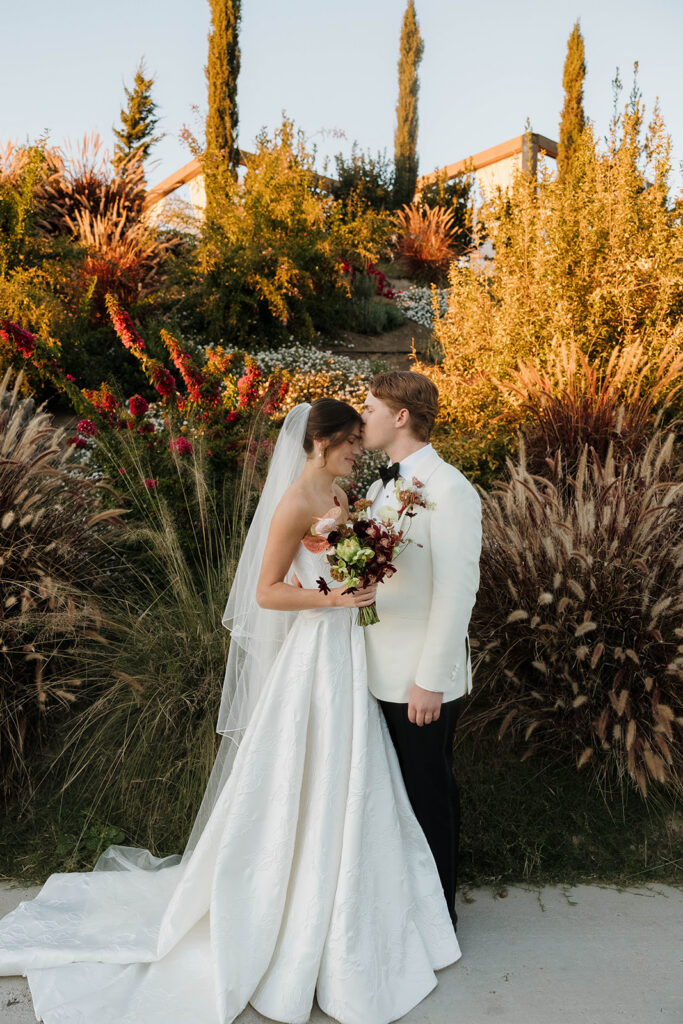 elegant bride and groom in the gardens at jeune perche, a european inspired wedding venue in california