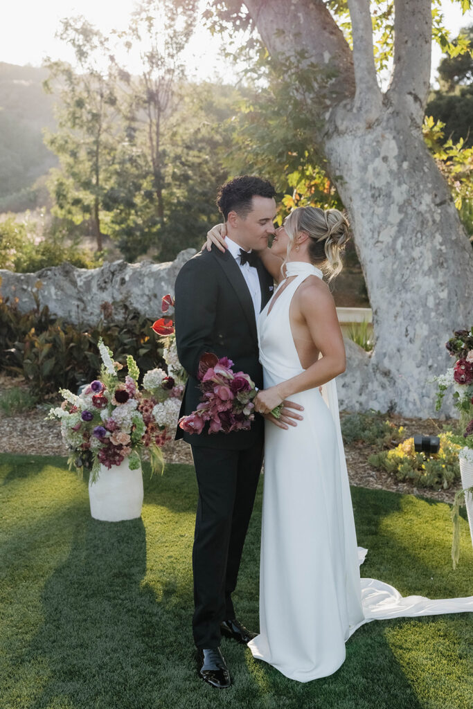 bride and groom kissing at the ceremony tree during their Monserate winery wedding