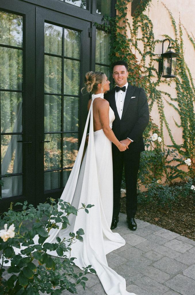 bride and groom posing in front of Monserate winery, their California wedding venue