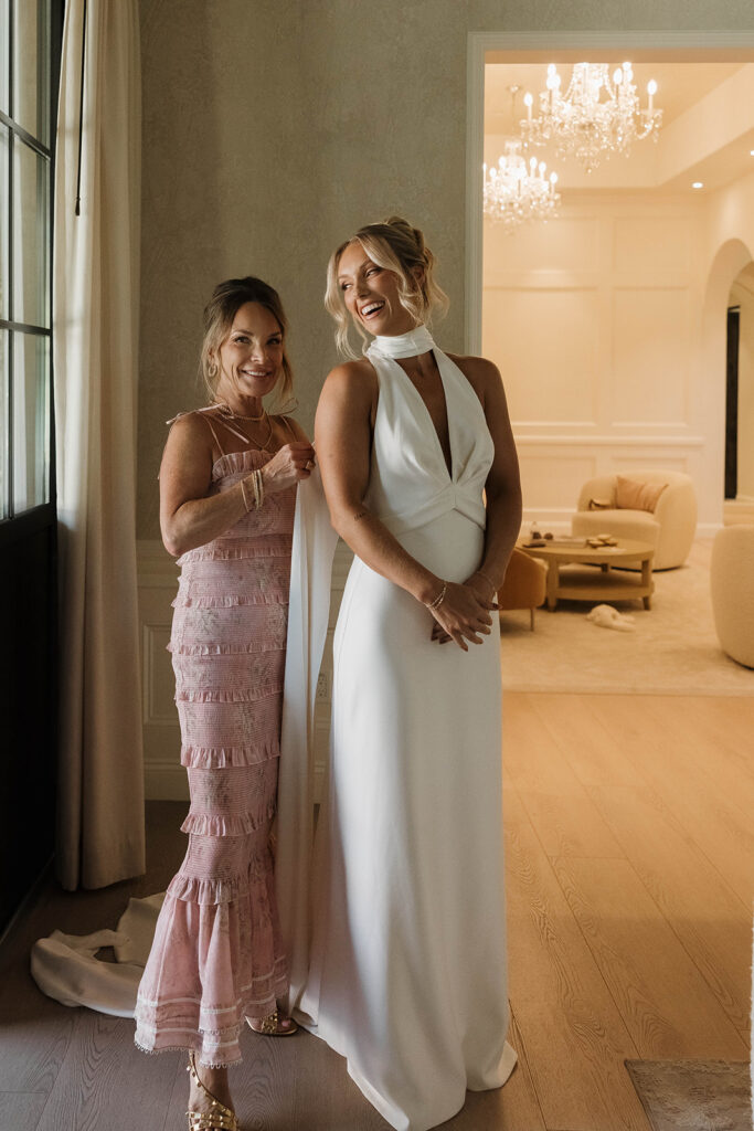 mom helping bride get ready at a clean getting ready suite