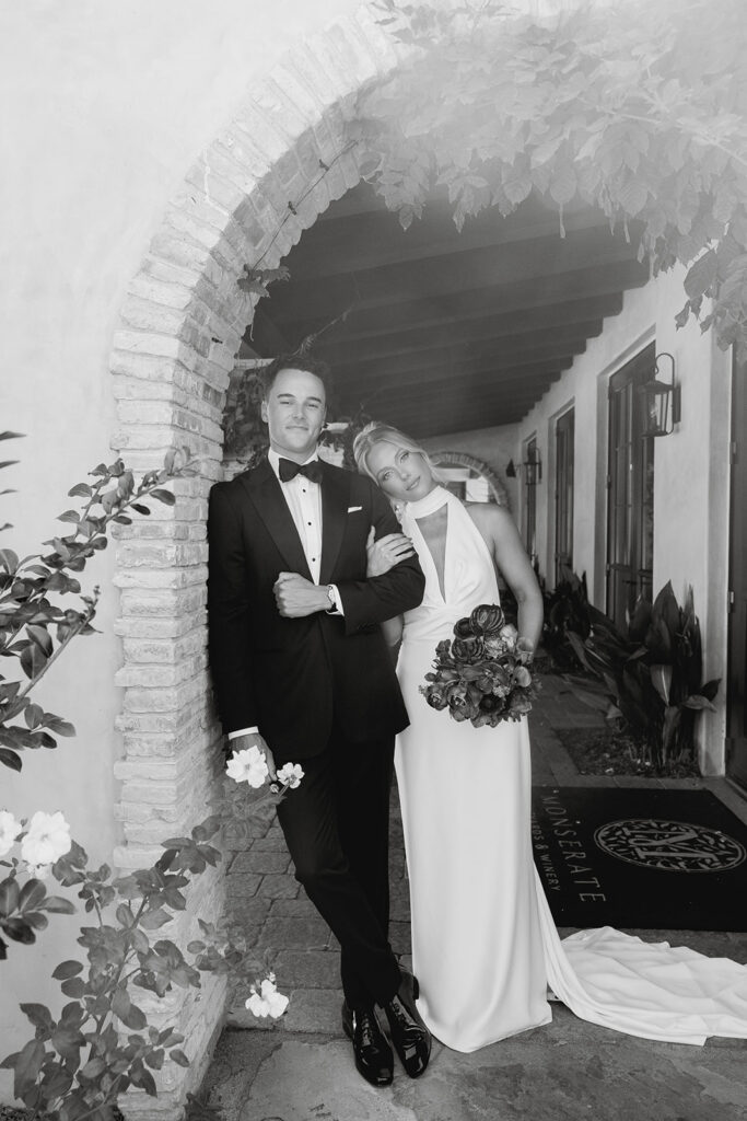 bride and groom posing in front of Monserate winery, their California wedding venue