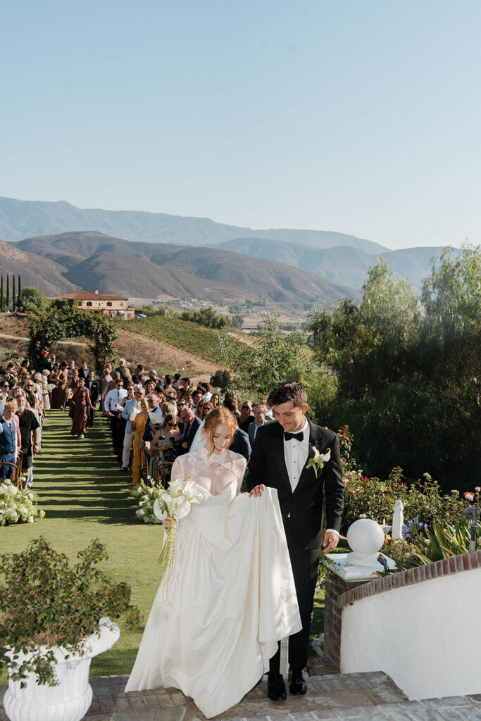bride and groom walking through their wedding ceremony space at the Morgan Estate wedding venue