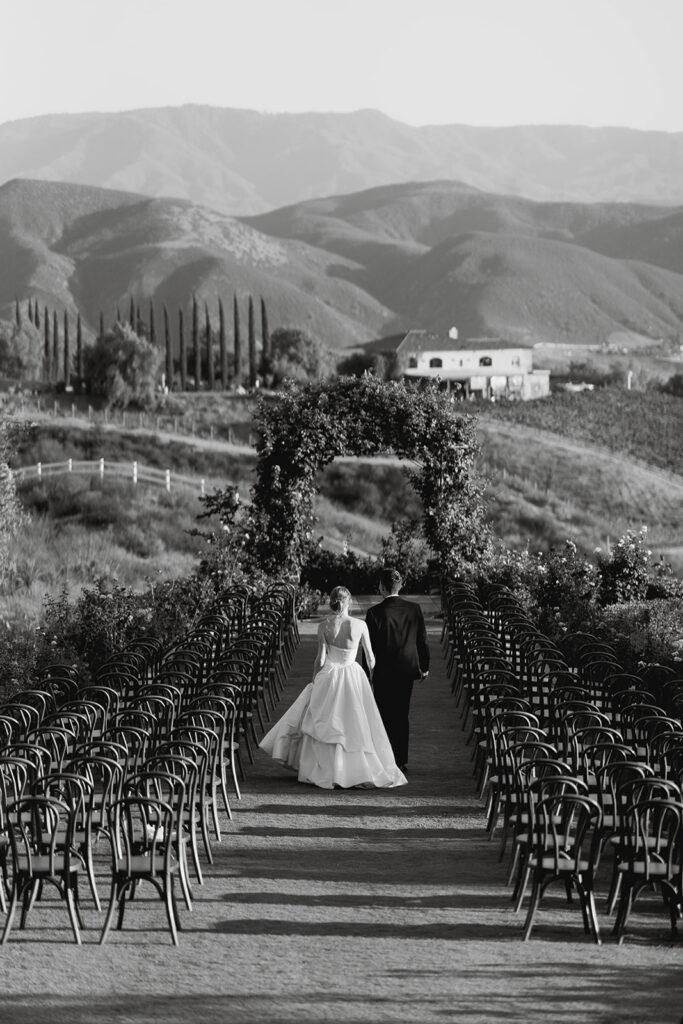 bride and groom walking through their wedding ceremony space at the Morgan Estate wedding venue