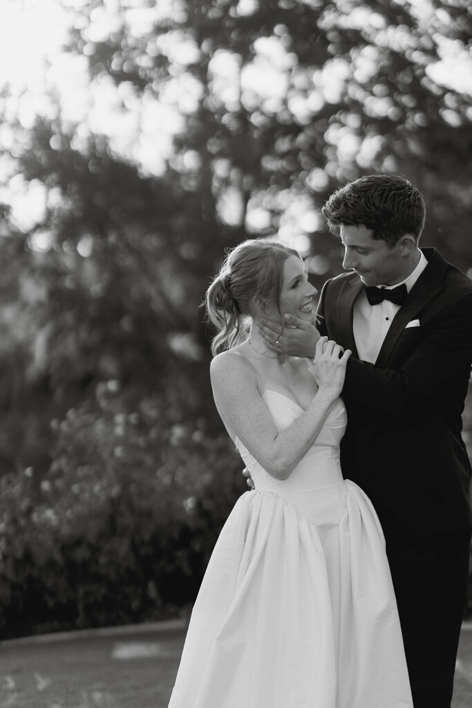 bride and groom posing at the lush green grounds during their Morgan Estate wedding in Temecula, CA