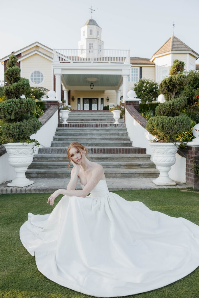 bride sitting at the bottom of the stairs in front of their morgan estate wedding venue