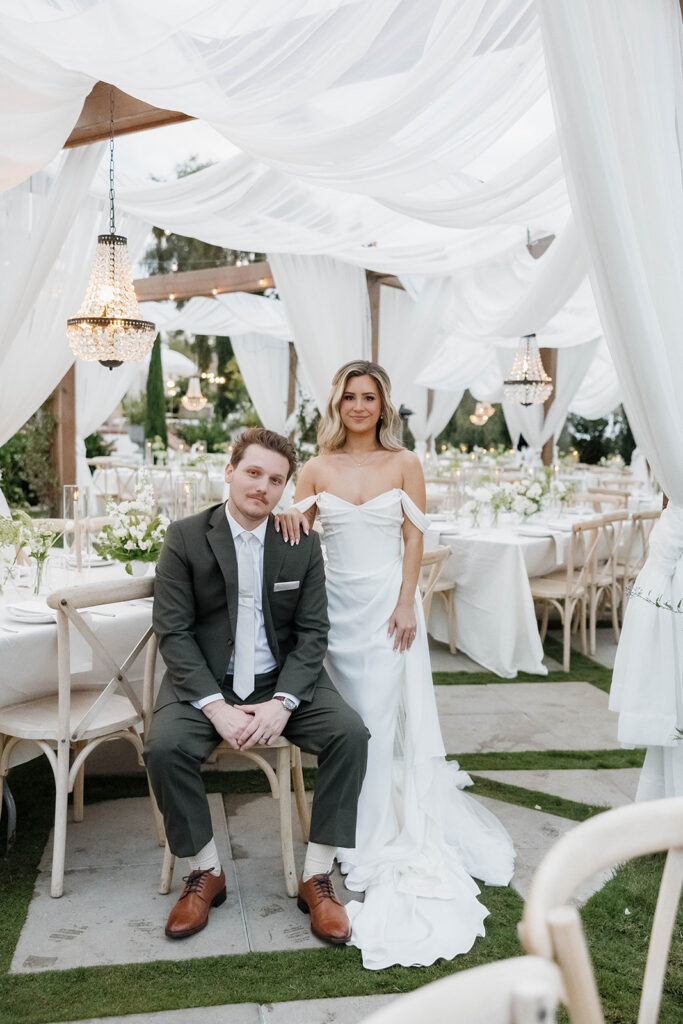bride and groom posing with their elegant outdoor wedding reception setup at jeune perche