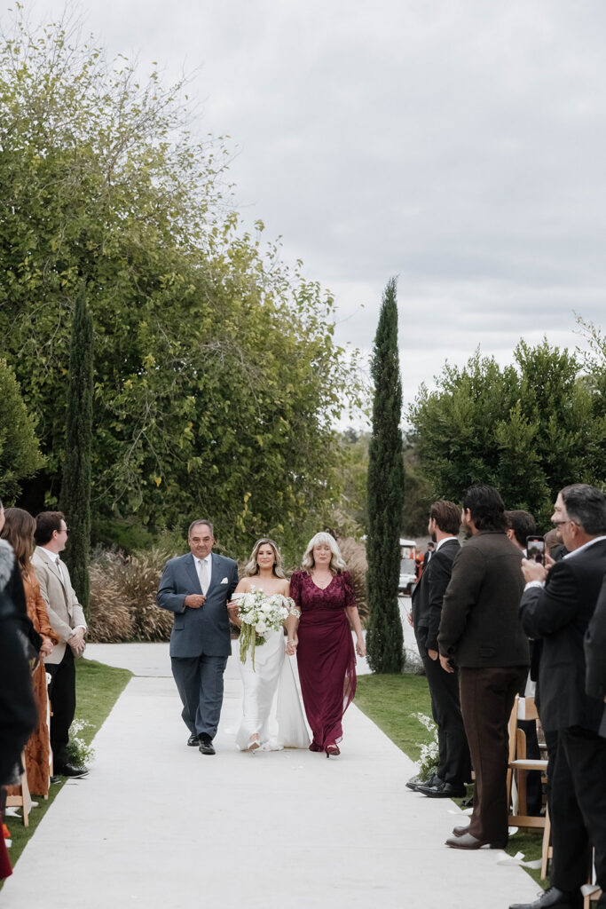 parents walking bride down the aisle
