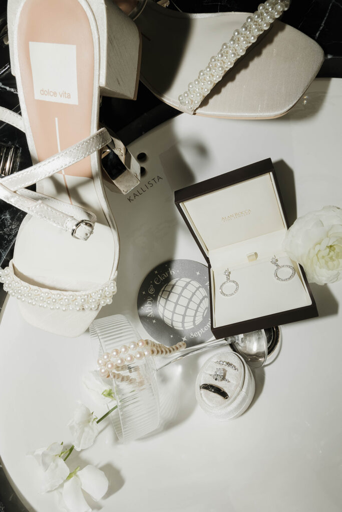 elegant wedding detail flatlay of shoes, rings and jewelry