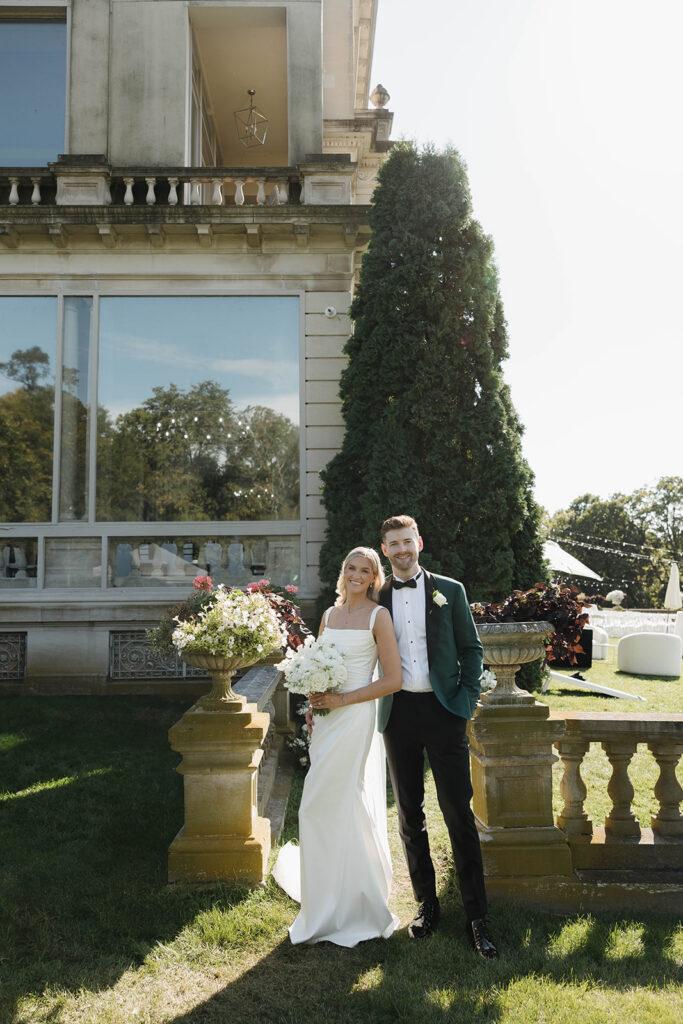 bride and groom posing in front of stone manor in lake geneva, wisconsin