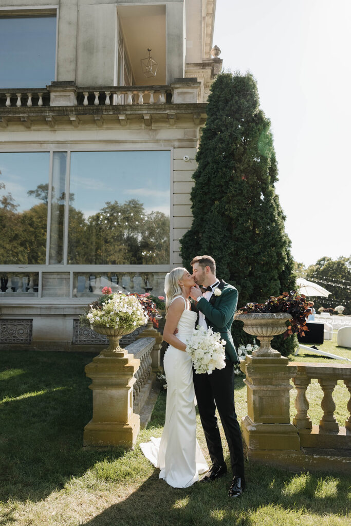 bride and groom kissing in front of stone manor in lake geneva, wisconsin