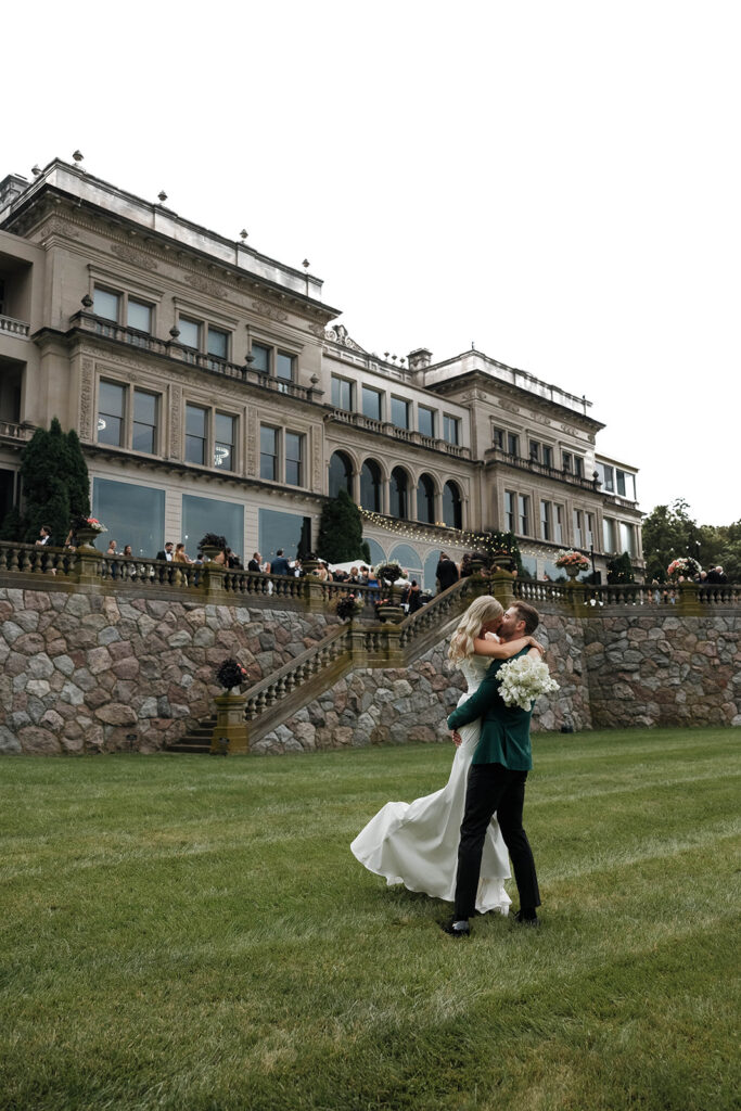 bride and groom kissing in front of stone manor in lake geneva, wisconsin