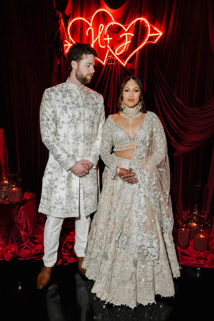 bride and groom in traditional indian wedding attire during their moody wedding reception at rancho bernardo inn