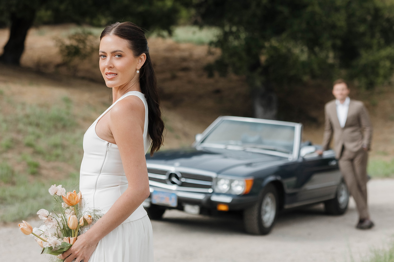 bride and groom posing with a vintage car during their ojai wedding