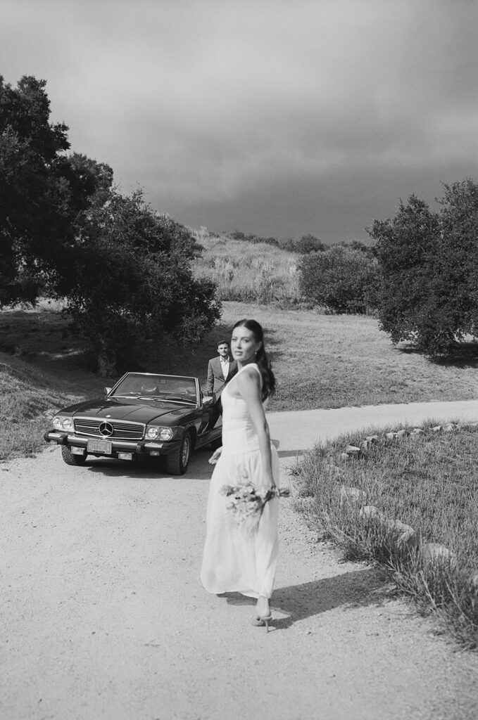 bride and groom posing with a vintage car during their ojai wedding