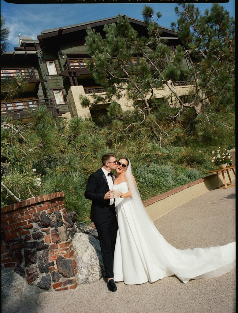 happy wedding couple posing in front of the lodge at torrey pines