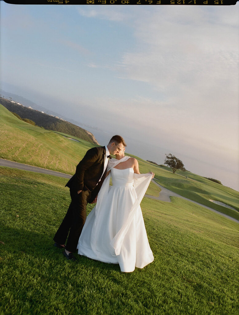 bride and groom roaming around the lush green lawns of at the lodge at torrey pines