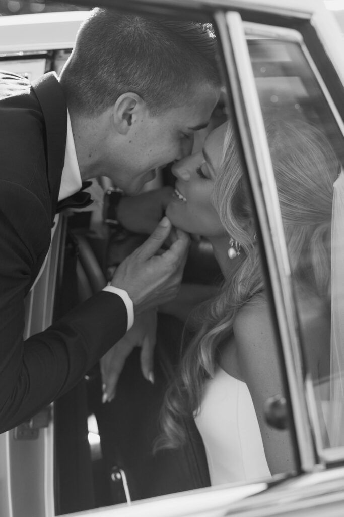 bride and groom kissing in a vintage car during their malibu wedding day at cielo farms